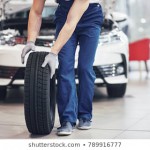 mechanic-holding-tire-repair-garage-260nw-789916777